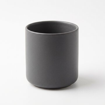 Minimalist matte charcoal ceramic mug, modern dark grey stoneware cup without handle, elegant porcelain vessel for coffee or tea
