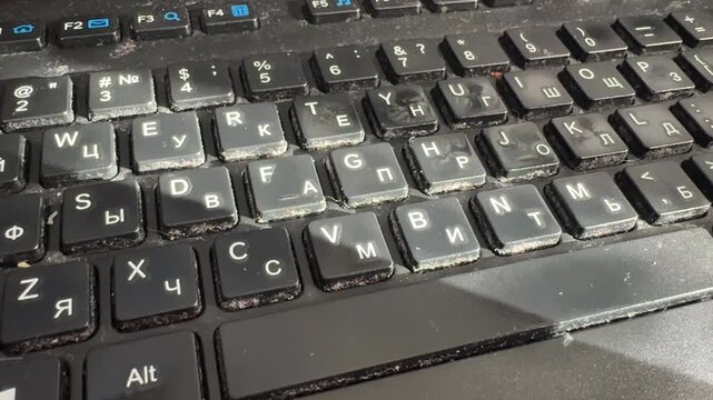 Barnaul, Russia, 15 July 2026 - Close-up of a dirty laptop keyboard covered in dust, debris, and grime between keys, showing neglect and poor maintenance.