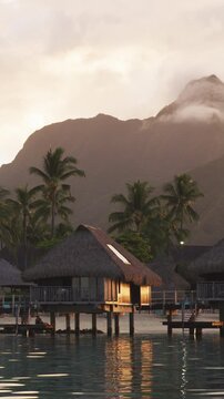 Travel vacation luxury resort hotel overwater bungalows on paradise beach. Romantic holidays destination on Moorea, French Polynesia. Raw vertical video.