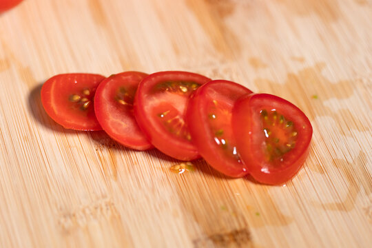 A sliced ripe tomato on a cutting board. Freshness, vegetable, contains vitamin C, potassium. Healthy eating, healthy lifestyle, raw food.