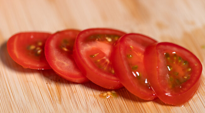 Close-up sliced ripe tomato on a cutting board. Freshness, vegetable, contains vitamin C, potassium. Healthy eating, healthy lifestyle, raw food.