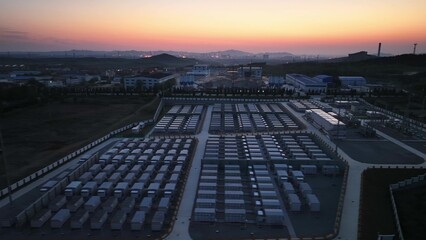 Fototapeta premium Large logistics warehousing park at dusk with panoramic view of container yards and industrial facilities
