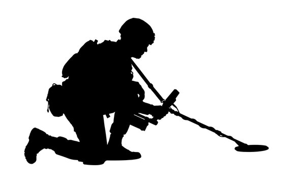 Silhouette of a soldier kneeling with a metal detector