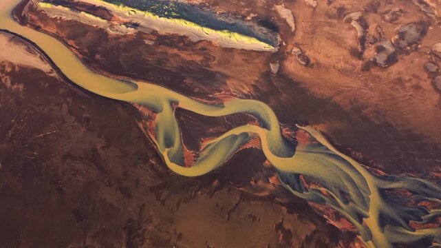 Aerial view of a winding river flowing through the volcanic landscape of Iceland.
