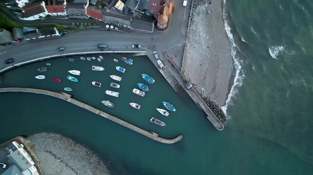 Aerial view of the harbor with small boats moored inside the stone walls in Lynmouth, England, United Kingdom.