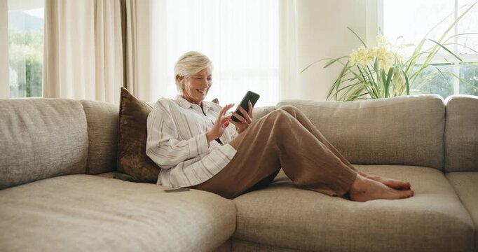 Mature, phone and happy woman with credit card on sofa for payment success or discount in home. Female person, shopper and debit with fist pump on smartphone for online shopping, deal or cashback app