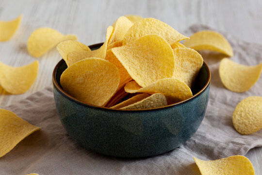 Crunchy Sour Cream and Onion Flavoured Potato Chips in a Bowl, side view. Close-up.