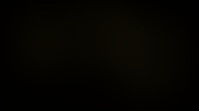 Golden light diffusion creates a soft glowing atmosphere in this smooth motion video footage transition that blends warm yellow hues and dark shadows into an elegant and fluid visual effect