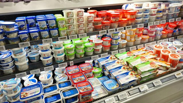 Grocery store dairy aisle stocked with various cheese products.