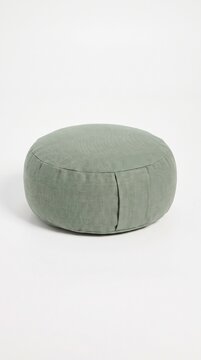 A round sage green textile meditation cushion sits centered on a white background. The soft olive tone evokes calm and mindfulness. Perfect for yoga studio branding or wellness product catalogs.