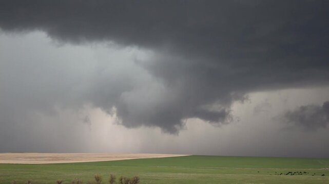 A wall cloud hangs beneath a supercell storm as it moves across the plains. Time lapse.