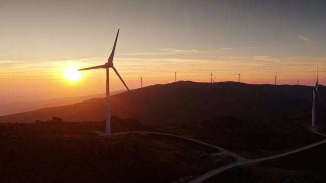 Wind farm across mountain ridges at sunset