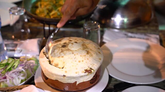 Traditional Matka (dum) biryani served in an earthenware clay pot at a restaurant table