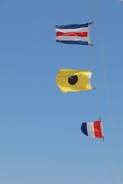 Nautical Flags Flying Against Clear Blue Sky