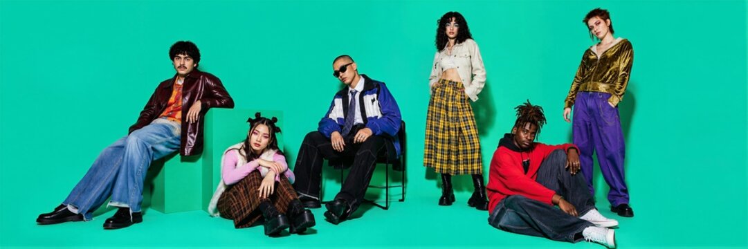 Group of diverse young men and women posing in y2k style outfits. Stylish zoomer fashion models wearing retro clothing on green background.
