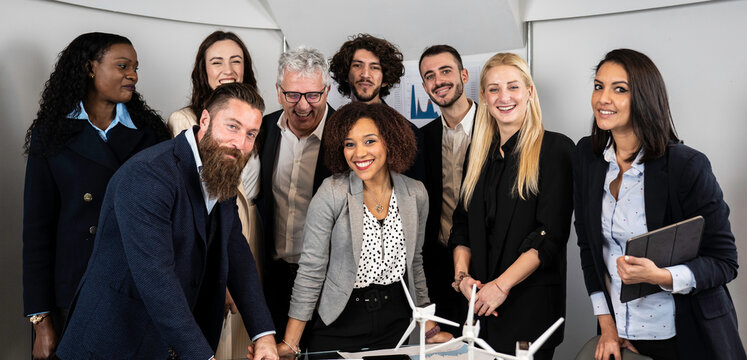 Multiethnic business people looking at camera inside corporate office for a group photo while working together on sustainable innovation project - Goal achievement concept