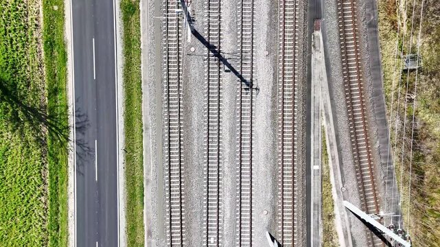Aerial view of Koralmbahn railway tracks running parallel to a road through the countryside in Deutschlandsberg, Steiermark, Austria.