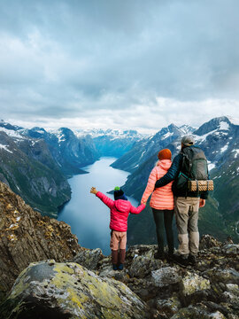 Family hiking in Norway travel vacations parents with child outdoor - father, mother and kid enjoying Eikesdalsvatnet lake and mountains aerial view, active healthy lifestyle explore Romsdal together