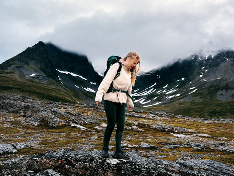 Woman hiking solo in northern Norway explore arctic nature travel active healthy lifestyle, autumn vacations mountains adventure tour outdoor happy tourist girl enjoying moody scenery candid emotions