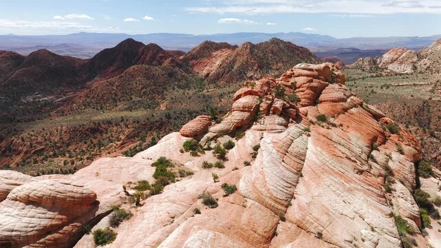 Aerial view of the rugged sandstone formations of the badlands with desert vegetation under a clear sky in Hanksville, Utah, United States.