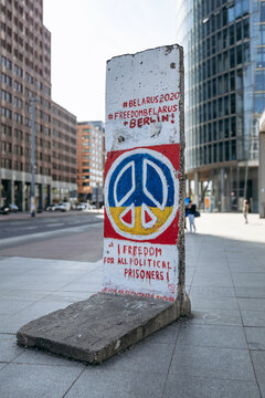 Berlin, Germany - April 23, 2026: Preserved Berlin Wall segment featuring peace symbol and pro-democracy graffiti at the Berlin Wall Exhibition near Potsdamer Platz.
