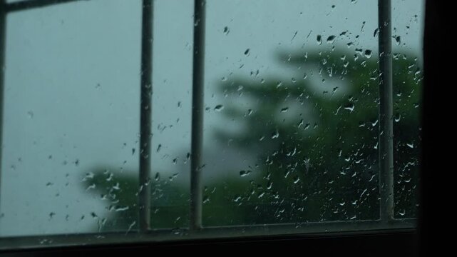 handheld close up of raindrops on window glass in dark evening atmosphere