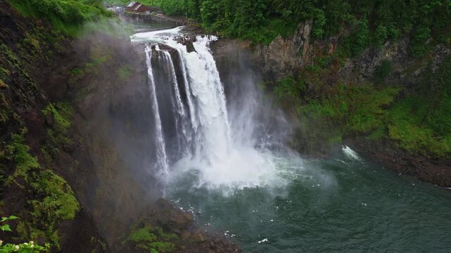 Snoqualmie Falls drops into the Snoqualmie River canyon amid lush evergreen forest and rising mist in Washington State, USA. 4K UHD video.