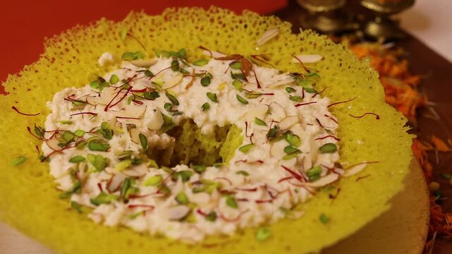 Ghewar a rajasthani sweet garnished with dry fruits and rabdi