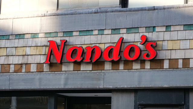 Leicester, England, UK - 19 July 2026: Nando's restaurant sign, red logo on building facade, fast casual dining chain concept