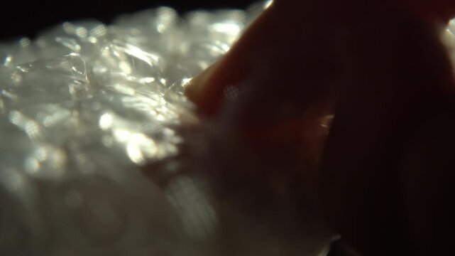 Macro thumb popping bubble wrap for satisfaction