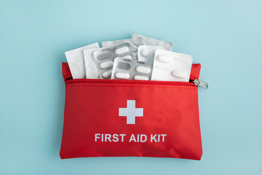 First aid kit with pills on blue background
