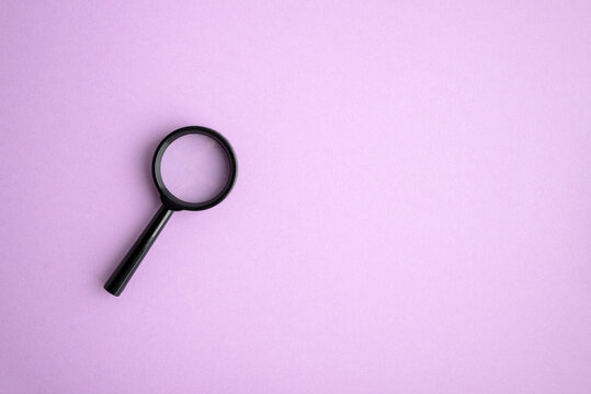 Magnifying glass isolated on purple background