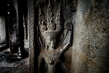 Fototapeta premium Ancient stone carving of a female Apsara dancer inside Angkor Wat temple in Siem Reap, Cambodia