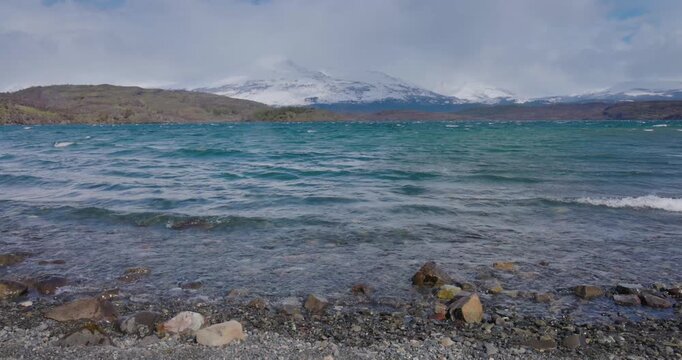 4K video; Landscape with a lake in windy weather and snow covered mountains in the background, Bahia el Bote in Torres del Paine National Park Patagonia Chile