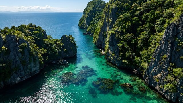 Aerial view of a narrow turquoise lagoon surrounded by steep green tropical limestone cliffs.