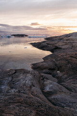 Fototapeta premium Rocky Arctic shoreline during the midnight sun in Ilulissat, Greenland