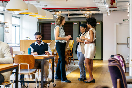 Diverse professionals networking and working in a contemporary, open plan office, fostering collaboration and an inclusive business environment