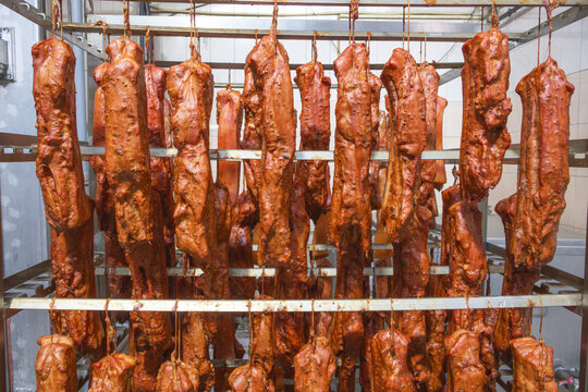 Smoked pork loin hanging in a smokehouse during the smoking process