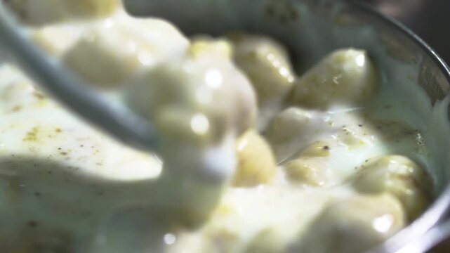 Extreme close up macro shot of creamy Boondi Raita showcasing tiny crispy boondi pearls and rich yogurt texture.