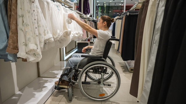 A Caucasian woman in a wheelchair shopping at a mall. 