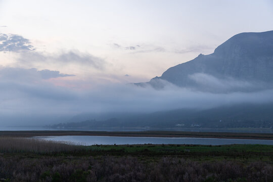 delicate fog hovering below Klein Mountains and lagoon, Stanford, South Africa