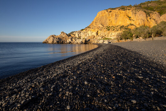 Black pebble beach Mavra Volia with dramatic volcanic cliffs near Emporios on the greek island of Chios. 