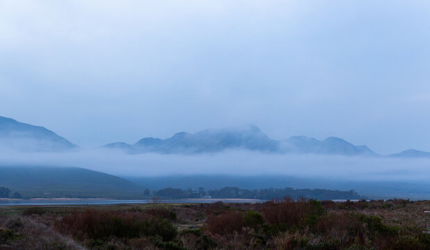 delicate fog hovering below Klein Mountains and lagoon, Stanford, South Africa