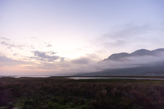 delicate fog hovering below Klein Mountains and lagoon, Stanford, South Africa
