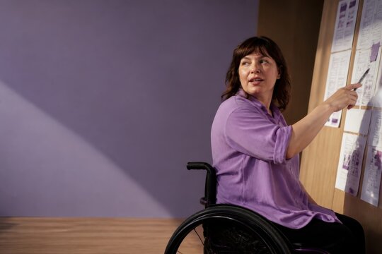 Wheelchair user leading inclusive planning meeting in an office