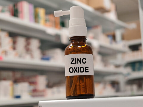 ZINC OXIDE topical skin relief spray for itching, irritation and inflammation with pharmacy warehouse drawers in the background