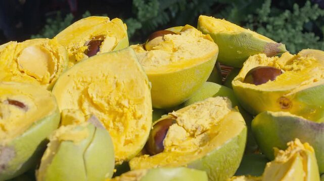 Fresh Whole and Sliced Peruvian Lucuma Fruit in a White Bowl