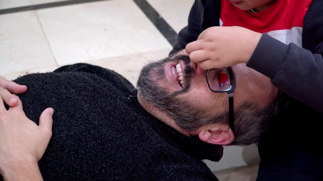 father and son playing with christmas decoration at home
