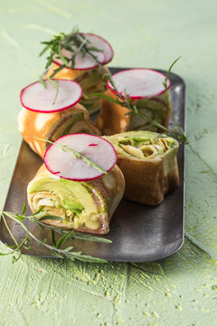 Crepe pancakes with avocado, soft white cheese and smoked salmon