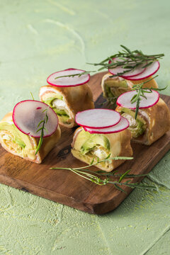 Crepe pancakes with avocado, soft white cheese and smoked salmon
